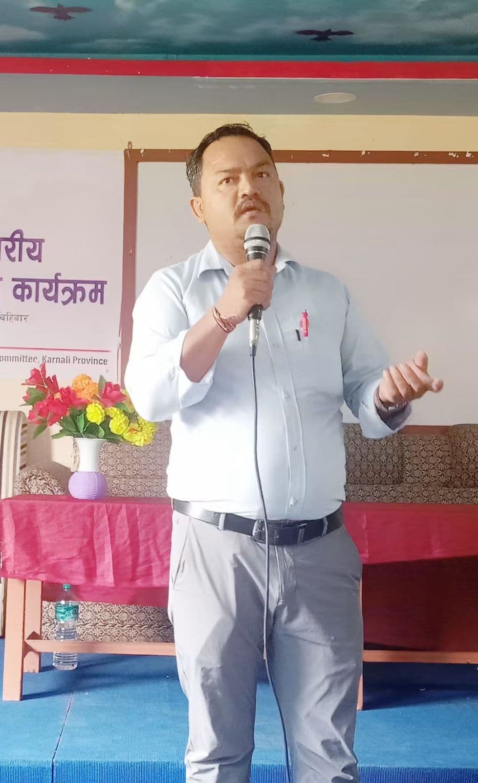Tej Prakash GC speaking with a microphone at a programme in Karnali Province
